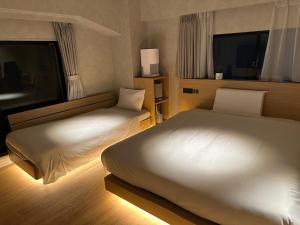 a hotel room with two beds and a window at 脈 -MYAKU PRIVATE SAUNA- in Fukuoka +32 photos