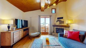 ein Wohnzimmer mit einem blauen Sofa und einem TV in der Unterkunft No 8 Bed & Bar in Verbier