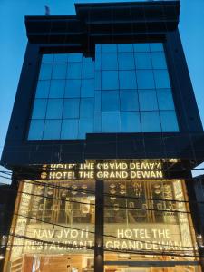 a tall building with a sign on the front of it at Hotel The Grand Dewan in Katra