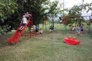 a group of children playing on a playground at Hotel Geromichalos in Paralía Skotínis