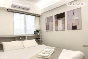 a bedroom with a bed with two towels on it at 2B1bLDK Zhongxiao Dunhua, Ultra Center City • 2房1衛 客廳廚房 忠孝敦化 黃金地段市中心 in Taipei