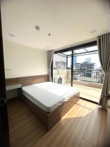a bedroom with a bed and a large window at Era Apartment Trung Liet in Hanoi