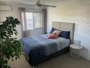 1 dormitorio con 1 cama con sábanas y almohadas azules en River View Getaway - Great Location en Maroochydore