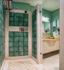 ein Badezimmer mit einer Dusche mit grünen Wänden in der Unterkunft Khamma Ghani A Boutique Hotel in Udaipur