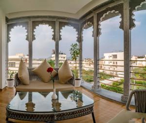 a living room with a couch and a glass table at Khamma Ghani A Boutique Hotel in Udaipur