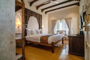 1 dormitorio con cama y espejo grande en Khamma Ghani A Boutique Hotel, en Udaipur