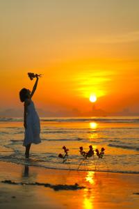 Una ragazza in piedi sulla spiaggia al tramonto di DoubleTree by Hilton Shanwei a Shanwei