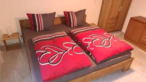 - un lit avec 2 oreillers rouges dans l'établissement Fewo unter der Kühlung, à Bastorf