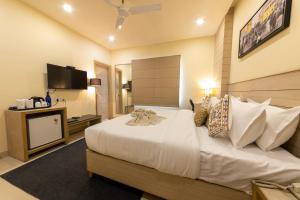1 dormitorio con 1 cama grande y TV en Perfectstayz Sagar Near Golden Temple en Amritsar