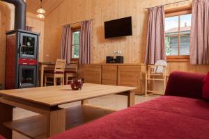 uma sala de estar com uma mesa de madeira e uma televisão em Chalet Ferienwohnungen em Brennberg