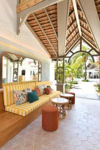 a living room with a couch on a patio at Veranda Palmar Beach Hotel & Spa - All Inclusive in Belle Mare