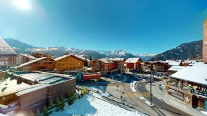 una pequeña ciudad con nieve en los tejados de edificios en No 8 Bed & Bar, en Verbier