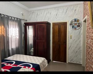 1 dormitorio con 1 cama y puerta de madera en Holiday Appartment Elbe en Lomé