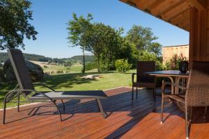 a wooden deck with a table and chairs on it at Chalet Ferienwohnungen in Brennberg