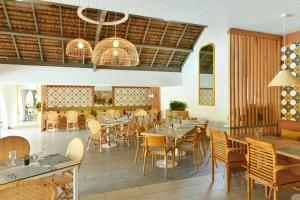 um restaurante com mesas e cadeiras num quarto em Veranda Palmar Beach Hotel & Spa - All Inclusive em Belle Mare