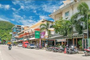 a street with motorcycles parked in front of a building at Dome Resort SHA Plus in Kata Beach