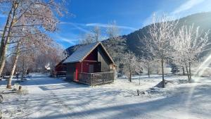 eine rote Hütte im Schnee mit einem Berg in der Unterkunft Chalets de la Wormsa in Metzeral