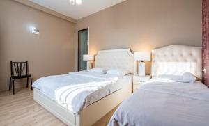 1 dormitorio con 2 camas y 1 silla en Urban Villa By Umbrella, en Tiflis