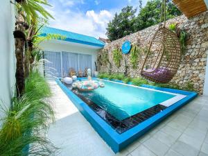 een zwembad in de tuin van een huis bij Ubu Villa Tropicola - Near Yogyakarta City Center in Seturan