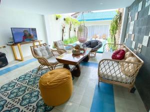 a living room with a couch and a table and chairs at Ubu Villa Tropicola - Near Yogyakarta City Center in Seturan