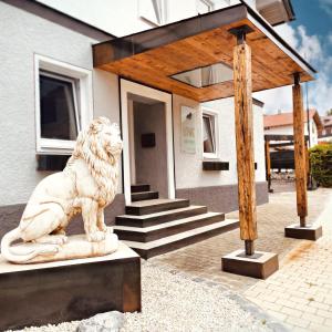 a statue of a lion in front of a house at Löwe Apartments in Oy-Mittelberg