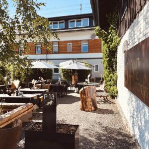 eine Terrasse mit Tischen und Sonnenschirmen vor einem Gebäude in der Unterkunft Löwe Apartments in Oy-Mittelberg