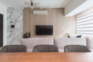 a dining room with a table and chairs and a television at New Building Home 3B2b Daan Park MRT-2min 全新大樓家 3房2衛 2分到大安森林公園站 in Taipei