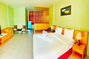 a bedroom with a bed with a white flower on it at Dome Resort SHA Plus in Kata Beach