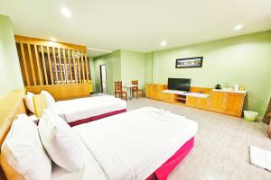 a hotel room with two beds and a television at Dome Resort SHA Plus in Kata Beach