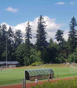 a group of people walking around a soccer field at New Private West Coast Guesthouse on the creek in North Vancouver