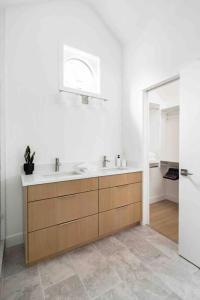 a white bathroom with a sink and a mirror at New Private West Coast Guesthouse on the creek in North Vancouver