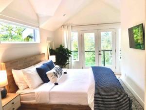 a bedroom with a large bed with blue and white pillows at New Private West Coast Guesthouse on the creek in North Vancouver