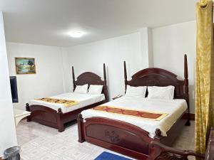 a bedroom with two beds and a flat screen tv at 万象莉莉酒店 in Vientiane