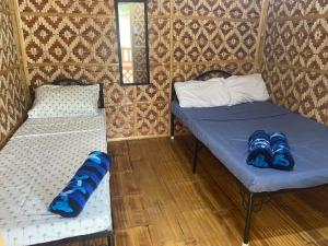 two beds in a room with blue and white sheets at B Ternate Resort in Dauin