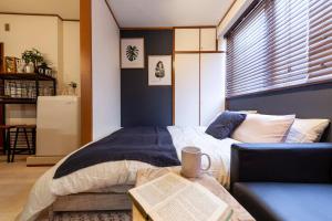 um quarto com uma cama, um sofá e um livro em Hills Komagome em Tóquio