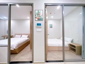 - une chambre avec 2 lits et une porte coulissante en verre dans l'établissement Căn hộ The Sóng - Hedone home, à Vung Tau