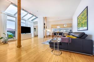 a living room with a black couch and a tv at Landhaus Bleckede - App Lüneburg in Bleckede