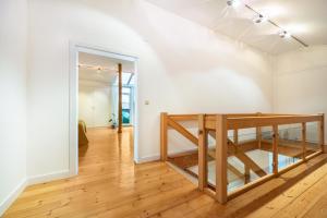 a hallway with a staircase in a white room with wood floors at Landhaus Bleckede - App 2 Lüneburg in Bleckede