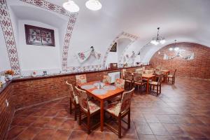 une salle à manger avec des tables et des chaises et un mur en briques dans l'établissement Conacul Domnesc, à Suceava