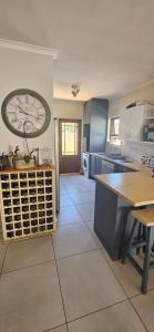 a kitchen with a large clock on the wall at Quaint Family home, walking distance to the beach in Cape Town