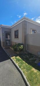 a small house with a gate at Quaint Family home, walking distance to the beach in Cape Town