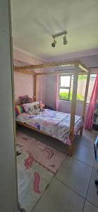 a bedroom with a bed with a canopy at Quaint Family home, walking distance to the beach in Cape Town