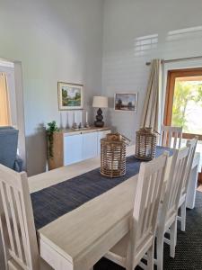 uma sala de jantar com uma mesa de madeira e cadeiras em Silver Ranch 2 em Keurboomstrand