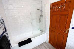 y baño con ducha y puerta de cristal. en Inspired Stays- City Centre- Spacious 4 Bed House!, en Stoke on Trent
