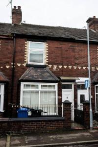 a brick house with a window and a fence at Inspired Stays- Close to City Centre- 4 Bed House! in Ford Green