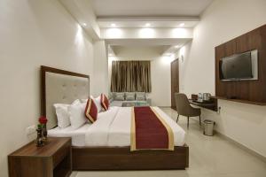 um quarto de hotel com uma cama e uma televisão em Hotel La Mirage em Noida