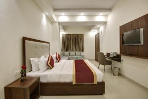 a hotel room with a bed and a television at Hotel La Mirage in Noida