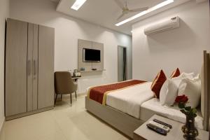 a bedroom with a bed and a desk and a tv at Hotel La Mirage in Noida +22 photos