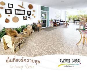 Thanaphat place في بوريرام: غرفة معيشة مع كنب وطاولات في غرفة
