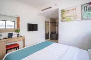 a bedroom with a bed and a desk and a tv at Floresta Hotel Chinatown in Kuala Lumpur